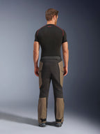 Alpinestars Cusco Drystar® Hose, Adventure-Motorradhose, Walnut Black, Rückansicht mit braunen und schwarzen Einsätzen, strapazierfähige Ripstop-Konstruktion, getragen mit einem schwarzen Base-Layer-Shirt