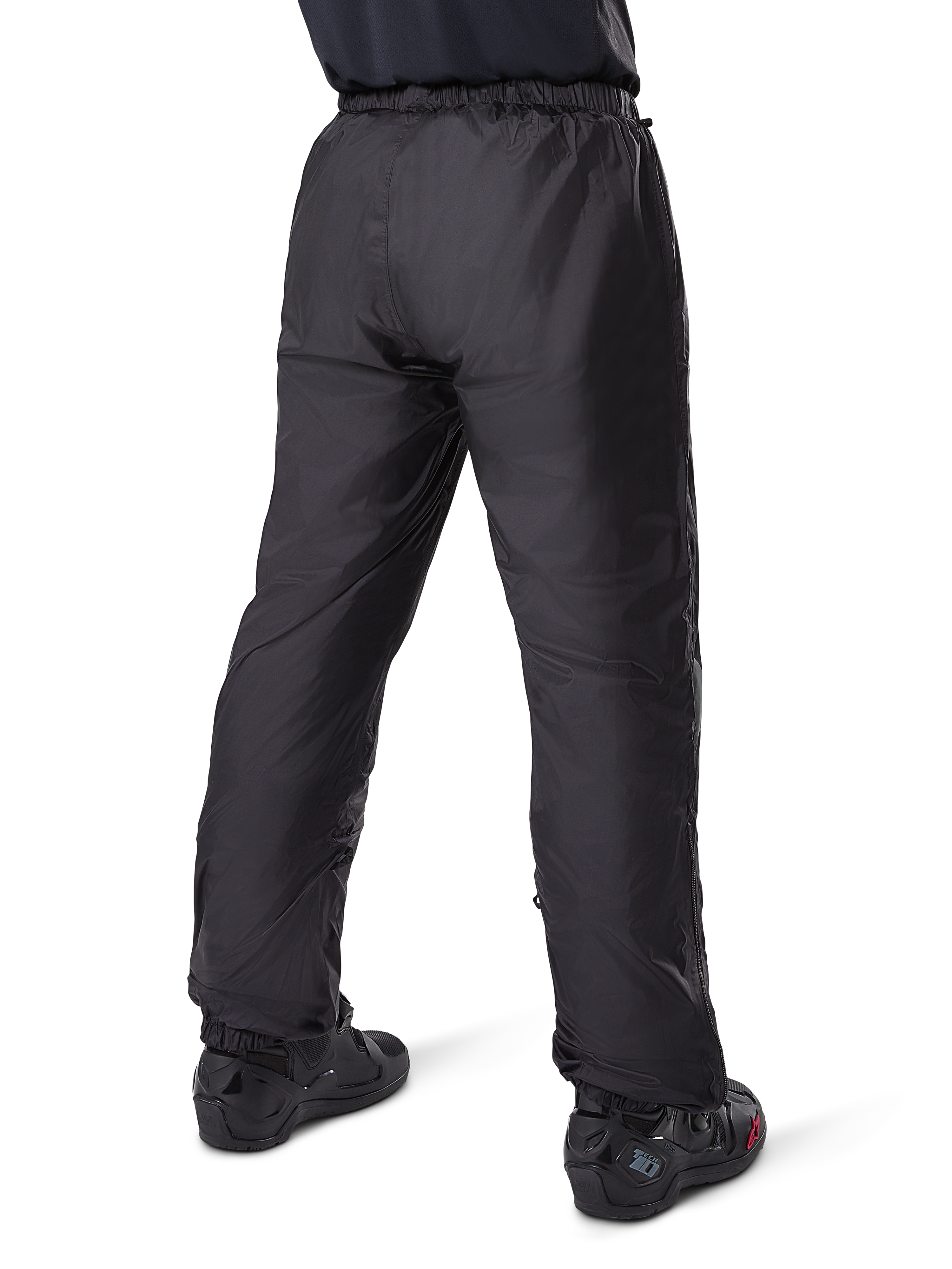 Alpinestars Bogota' Pro Drystar® 3-Jahreszeiten-Hose, schwarze Adventure-Touring-Motorradhose, Rückansicht des wasserdichten Drystar®-Futters als Überhose getragen, kombiniert mit schwarzen Motorradstiefeln, technische Leichtbaukonstruktion für Wetterschutz zu jeder Jahreszeit