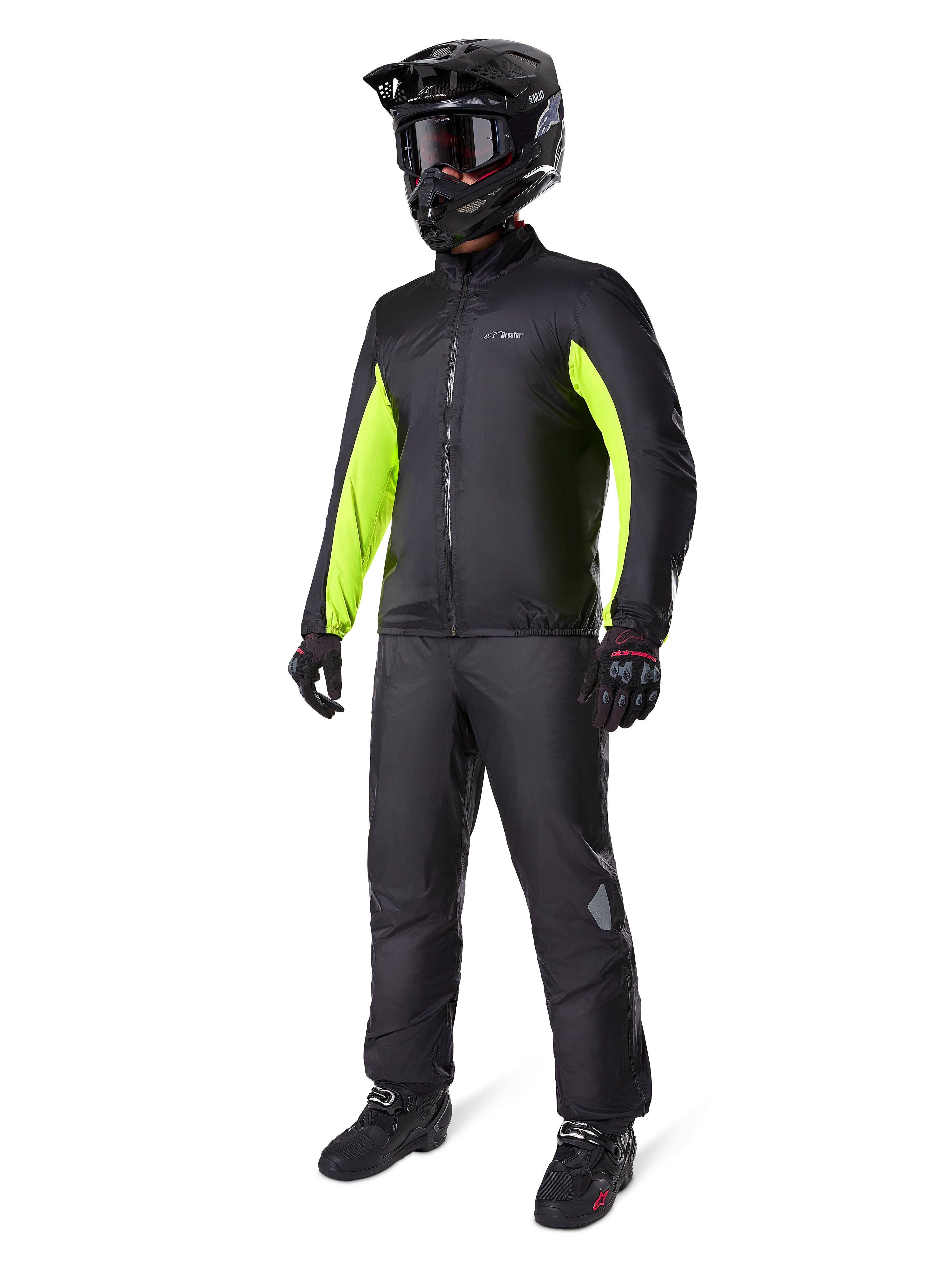 Alpinestars Bogota' Pro Drystar® 3-Jahreszeiten-Hose, Schwarz, Fahrer in kompletter Adventure-Touring-Ausrüstung inklusive schwarzer Jacke mit neongelben Akzenten, schwarzem Helm, Handschuhen und Stiefeln, zeigt die wasserdichte Drystar®-Membran, die über der Hose getragen wird