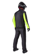 Fahrer in der Rückansicht trägt Alpinestars Bogotá Pro Drystar® 3-Jahreszeiten-Hose in Schwarz, kombiniert mit einer schwarzen Jacke mit neongelben Ärmeln, schwarzem Adventure-Helm und Stiefeln, komplette Adventure-Tourenausrüstung