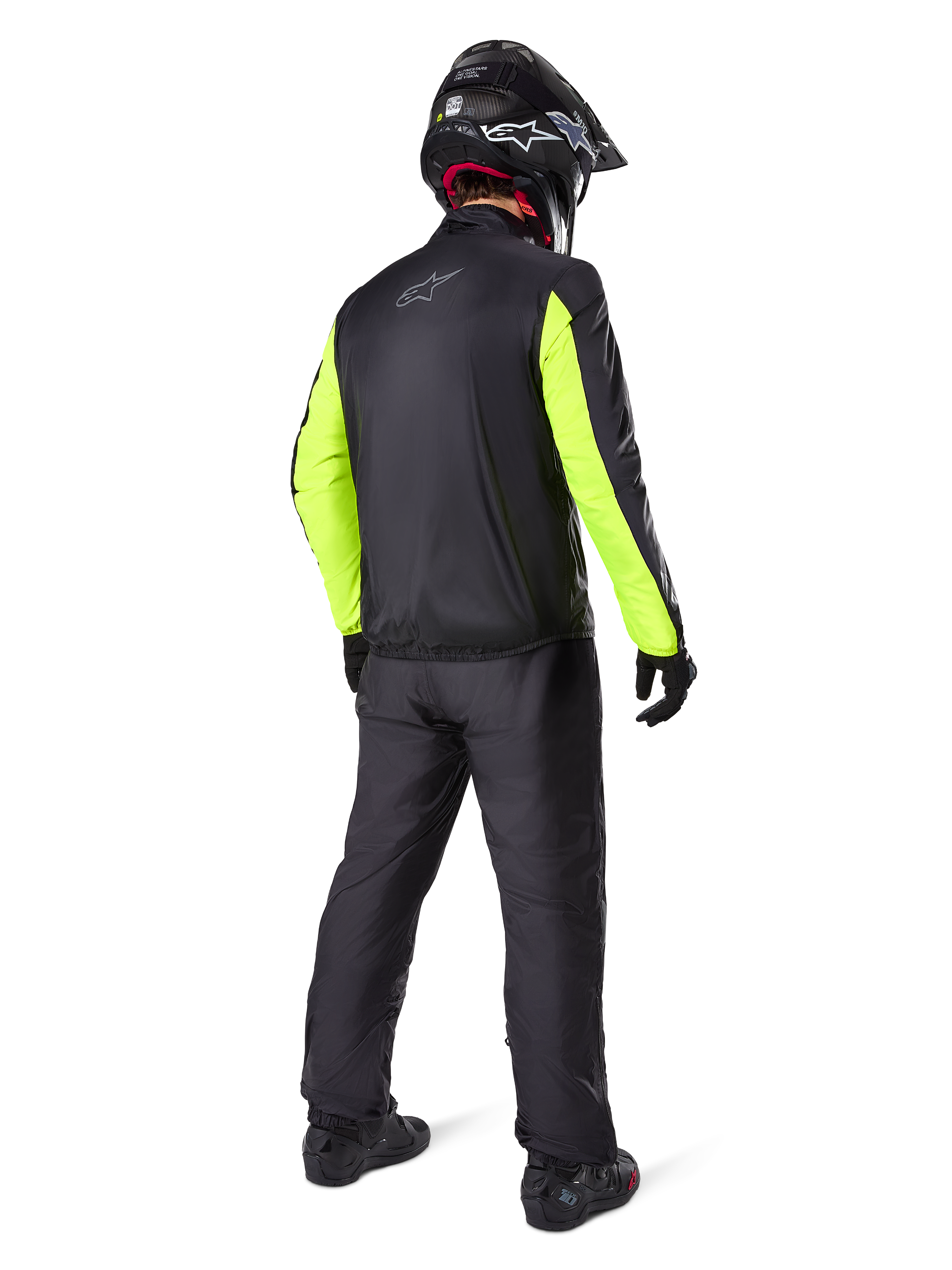 Fahrer in der Rückansicht trägt Alpinestars Bogotá Pro Drystar® 3-Jahreszeiten-Hose in Schwarz, kombiniert mit einer schwarzen Jacke mit neongelben Ärmeln, schwarzem Adventure-Helm und Stiefeln, komplette Adventure-Tourenausrüstung