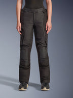 Alpinestars Stella Andes V4 Drystar® Hose, Damen-Adventure-Tourenhose, Schwarz, Vorderansicht, mit verstärkten Knieeinsätzen, wasserabweisenden Cargotaschen und verstellbaren Taillenriemen, getragen mit schwarzen Stiefeln in einer Studioumgebung.
