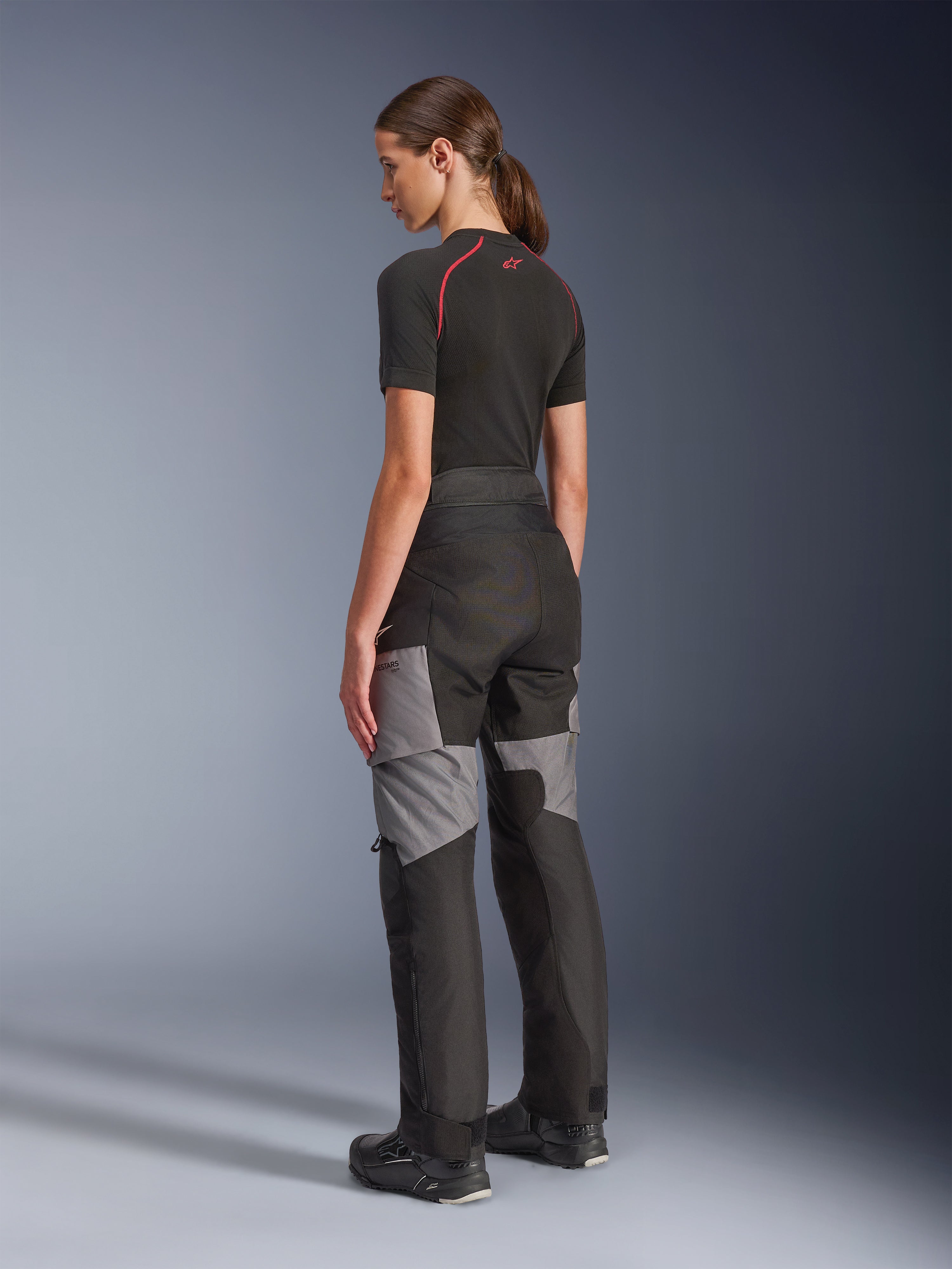 Stella Andes V4 Drystar® Hose für Damen, Motorrad-Adventure-Tourenhose, Schwarz und Dunkelgrau, Rück- und Seitenansicht am Model, mit strapazierfähiger Textilkonstruktion, grauen Verstärkungseinsätzen und einer speziell auf Fahrerinnen zugeschnittenen Passform.