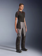 Alpinestars Stella Andes V4 Drystar® Hose, Adventure-Motorradhose für Damen, Schwarz und Dunkelgrau, getragen von einem Model mit schwarzem Alpinestars Base Layer und schwarzen Stiefeln, mit verstärkten Paneelen, rotem Drystar-Logo und Cargotaschen.