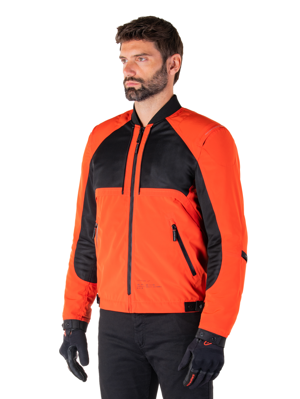 Alpinestars Mootant wasserdichter Parka in Spicy Orange und Schwarz, modulare Motorradjacke in der Bomberjacken-Konfiguration, mit schwarzen Mesh- und orangefarbenen Textileinsätzen, moderne urbane Fahrausrüstung, getragen mit schwarzen Handschuhen