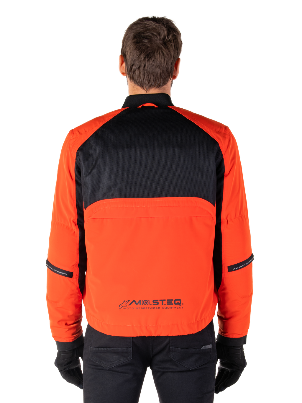 Alpinestars Mootant Wasserdichter Parka, Motorradjacke, Spicy Orange und Schwarz, Rückansicht, mit schwarzem Mesh am oberen Rücken und orangefarbenem unterem Panel mit MO.ST.EQ. Logo, kombiniert mit schwarzer Hose und Handschuhen