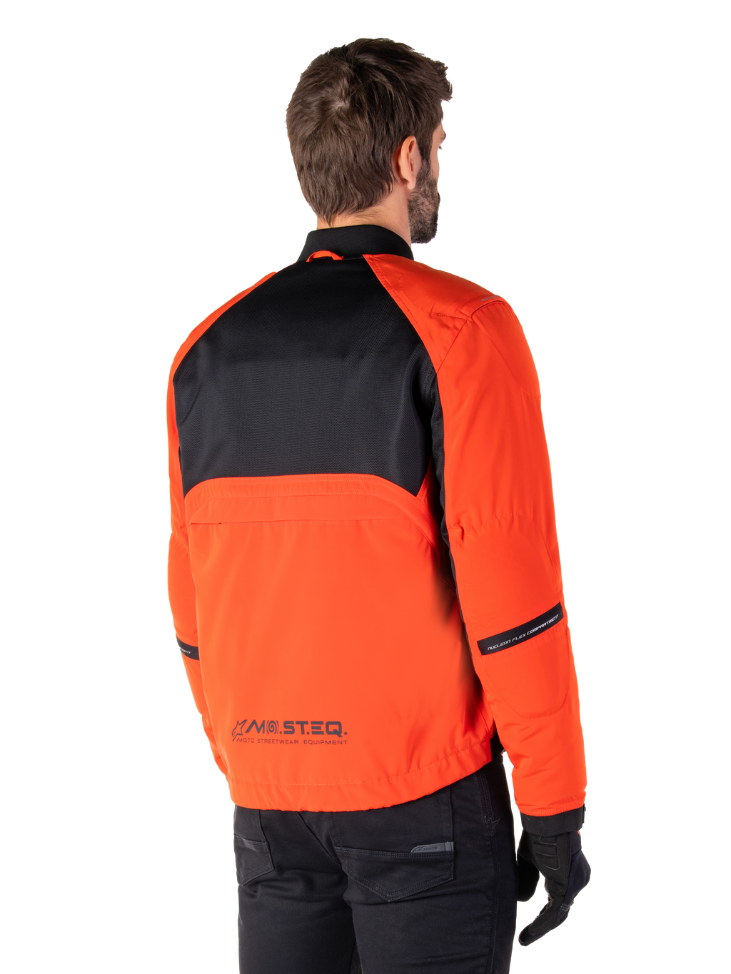 Rückansicht eines Fahrers im Alpinestars Mootant Waterproof Parka in Spicy Orange und Schwarz, mit schwarzem Mesh-Einsatz am oberen Rücken und reflektierendem MO.ST.EQ.-Branding, moderne funktionale Motorradjacke.