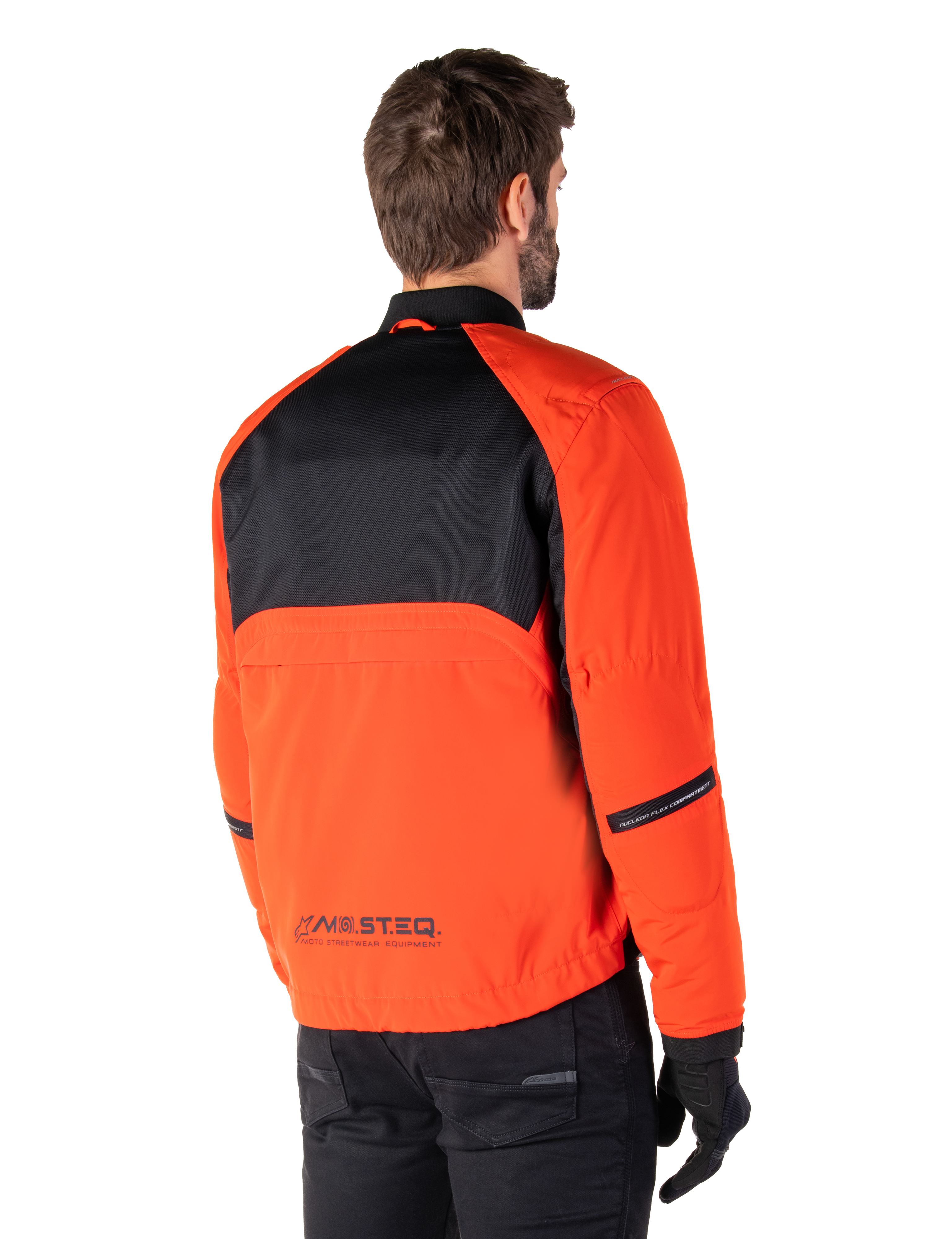 Rückansicht eines Fahrers im Alpinestars Mootant Waterproof Parka in Spicy Orange und Schwarz, mit schwarzem Mesh-Einsatz am oberen Rücken und reflektierendem MO.ST.EQ.-Branding, moderne funktionale Motorradjacke.