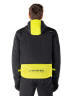 Alpinestars Mootant Waterproof Parka, Motorcycle Jacket, Lime Punch and Black, rear view showing hooded design and reflective MO.ST.EQ. branding on the lower back, worn with black riding pants and gloves.