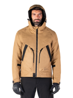Alpinestars Morush Wasserdichter Parka, Motorradjacke, Utility Brown, Kapuzendesign im Streetwear-Stil mit großen, schwarz akzentuierten Fronttaschen, kombiniert mit schwarzen Fahrhandschuhen und Hosen, moderne urbane Motorradausrüstung