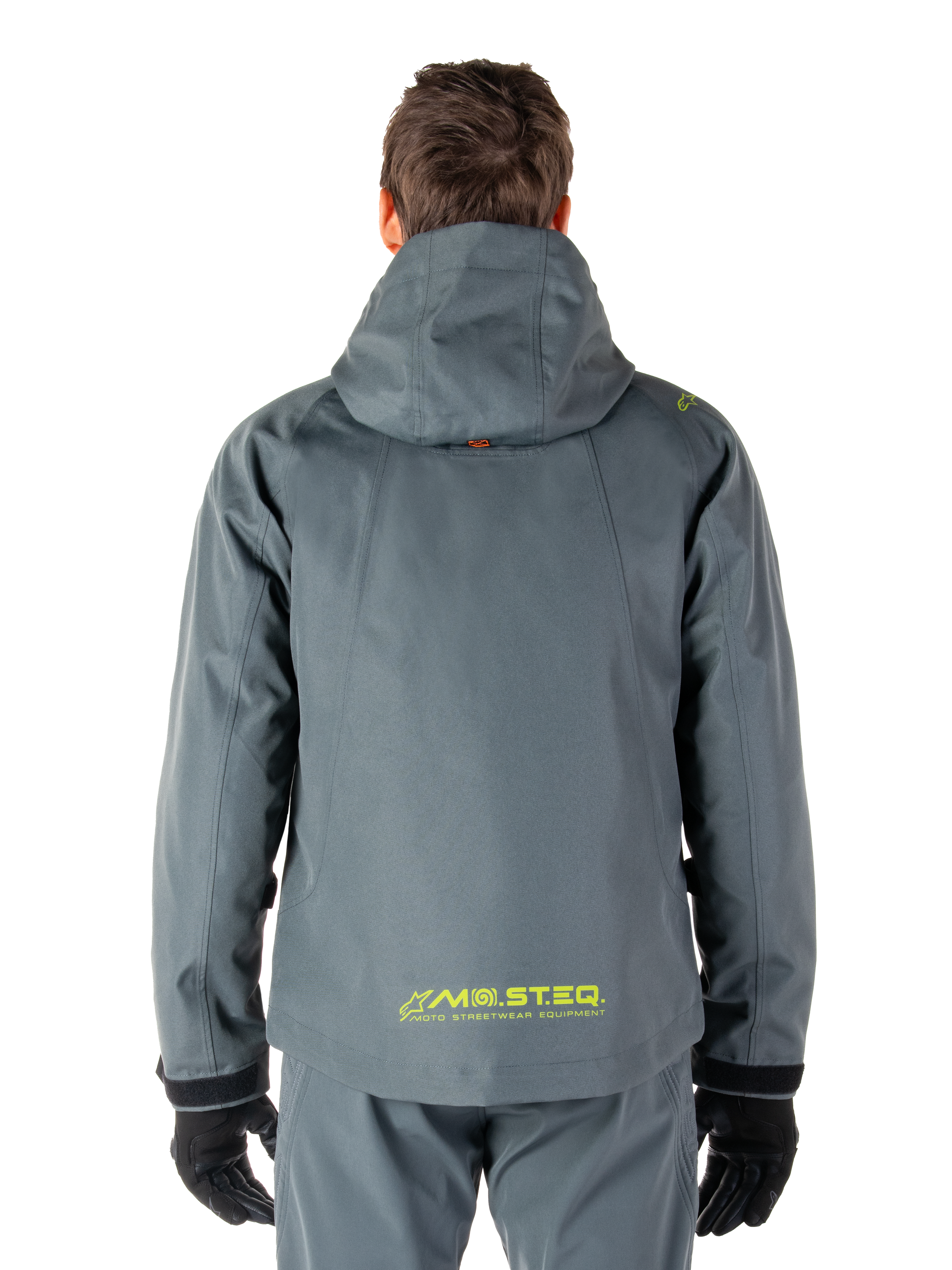 Alpinestars Morush Wasserdichter Parka, Motorradjacke, Urban-Grau, Rückansicht mit Kapuzendesign und gelbem MO.ST.EQ. Logo am unteren Rücken, moderne, von urbaner Streetwear inspirierte Motorradausrüstung