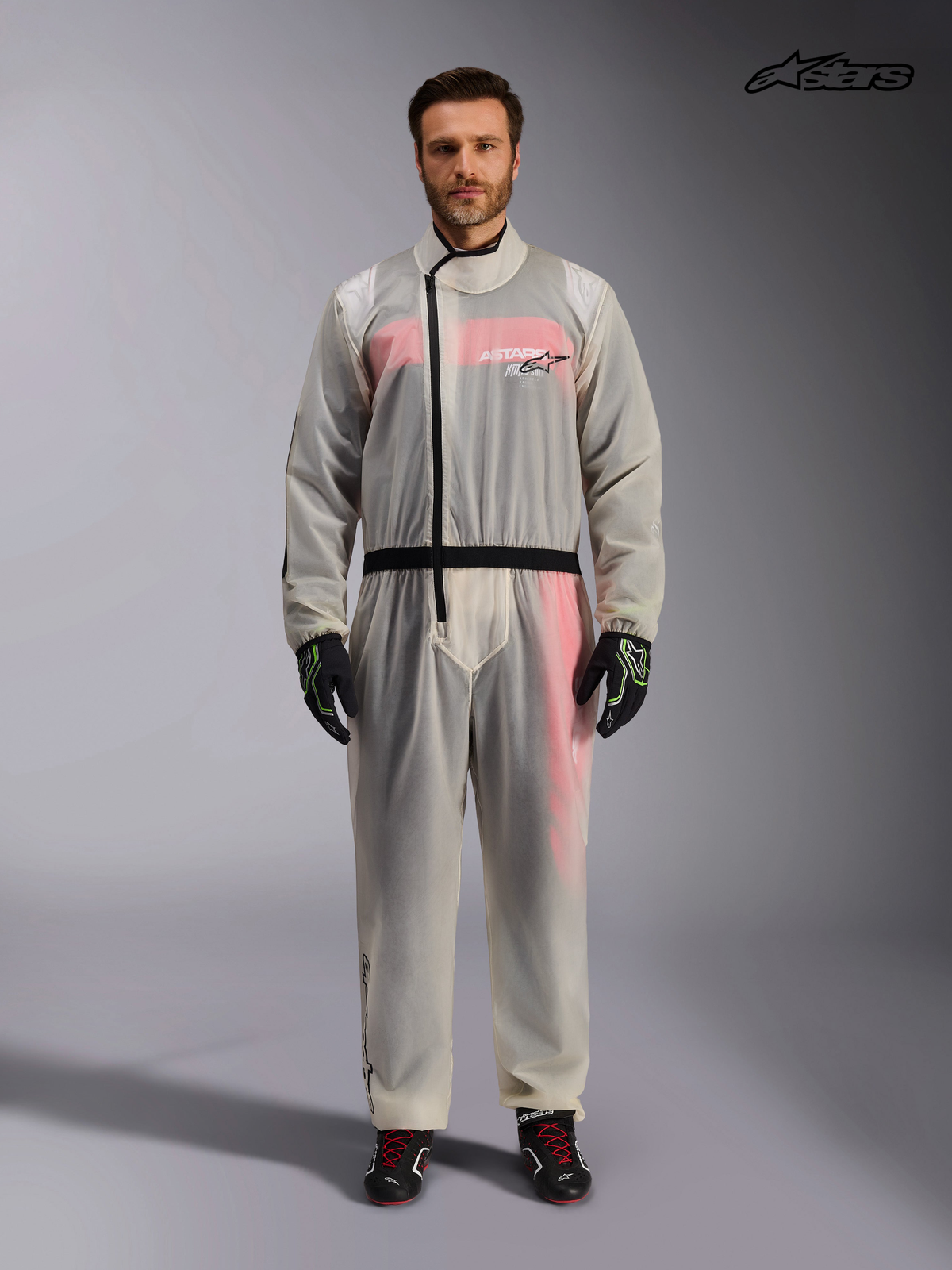 Alpinestars Kart Rain Suit, transparent waterproof karting oversuit for men in clear, front view on a model showing the asymmetric zipper and elasticized waist