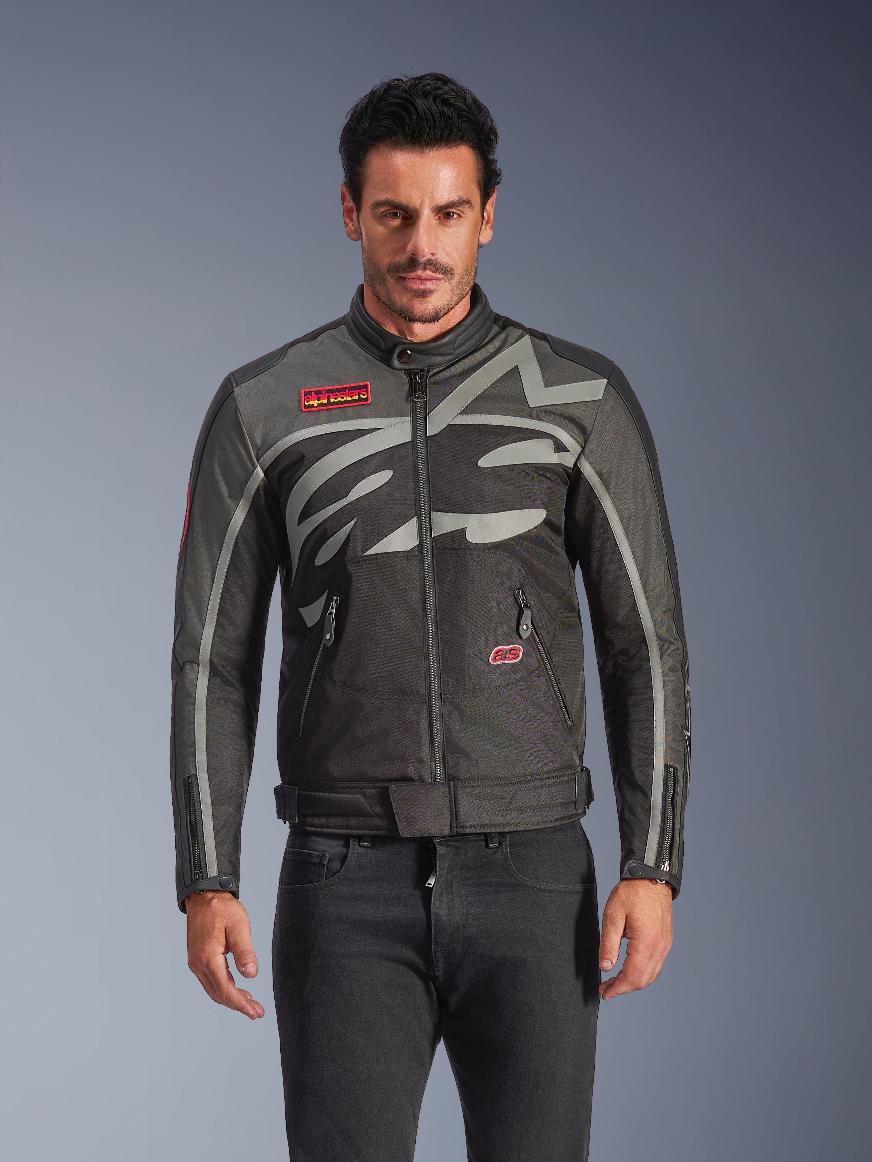 Alpinestars Axton Jacke, Urban-Motorradjacke für Herren, Schwarz und Anthrazit mit roten Akzenten, große umlaufende hellgraue Grafik, rote Logo-Patches auf Brust und Tasche, Frontreißverschluss und Reißverschluss-Manschetten, von Vintage-Rennsport inspiriertes Design für die Straße
