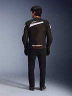 Alpinestars T-GP Plus R V4 Jacke, sportliche Textil-Motorradjacke in Schwarz und Weiß, Rückansicht mit weißem Alpinestars-Logo und „RACING AHEAD“-Branding, getragen mit schwarzer Hose und Stiefeln, stromlinienförmiges Design für sportliches Fahren.