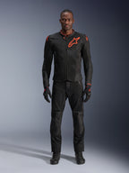 Alpinestars Viper Air V4 Jacke in Schwarz Rot Fluo, getragen von einem Modell mit passender schwarzer Hose und Handschuhen, mit Mesh-Einsätzen für Luftzirkulation und einem markanten roten Alpinestars-Logo auf der Brust, sportliche Motorrad-Straßenausrüstung.