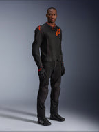 Model in der Alpinestars Viper Air V4 Jacke in Schwarz und Red Fluo, mit Mesh-Einsätzen und roten Stern-Logos auf der Brust und Schulter, kombiniert mit passender schwarzer Motorradhose, Handschuhen und Fahrschuhen, professionelles Motorrad-Outfit für die Straße