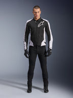 Alpinestars Viper Air V4 Jacke, schwarz-weiße Motorradjacke mit großem weißem Logo auf der Brust, getragen von einem männlichen Model mit schwarzer Hose und Handschuhen, mit Mesh-Panels zur Belüftung, sportliche Straßenmotorradbekleidung