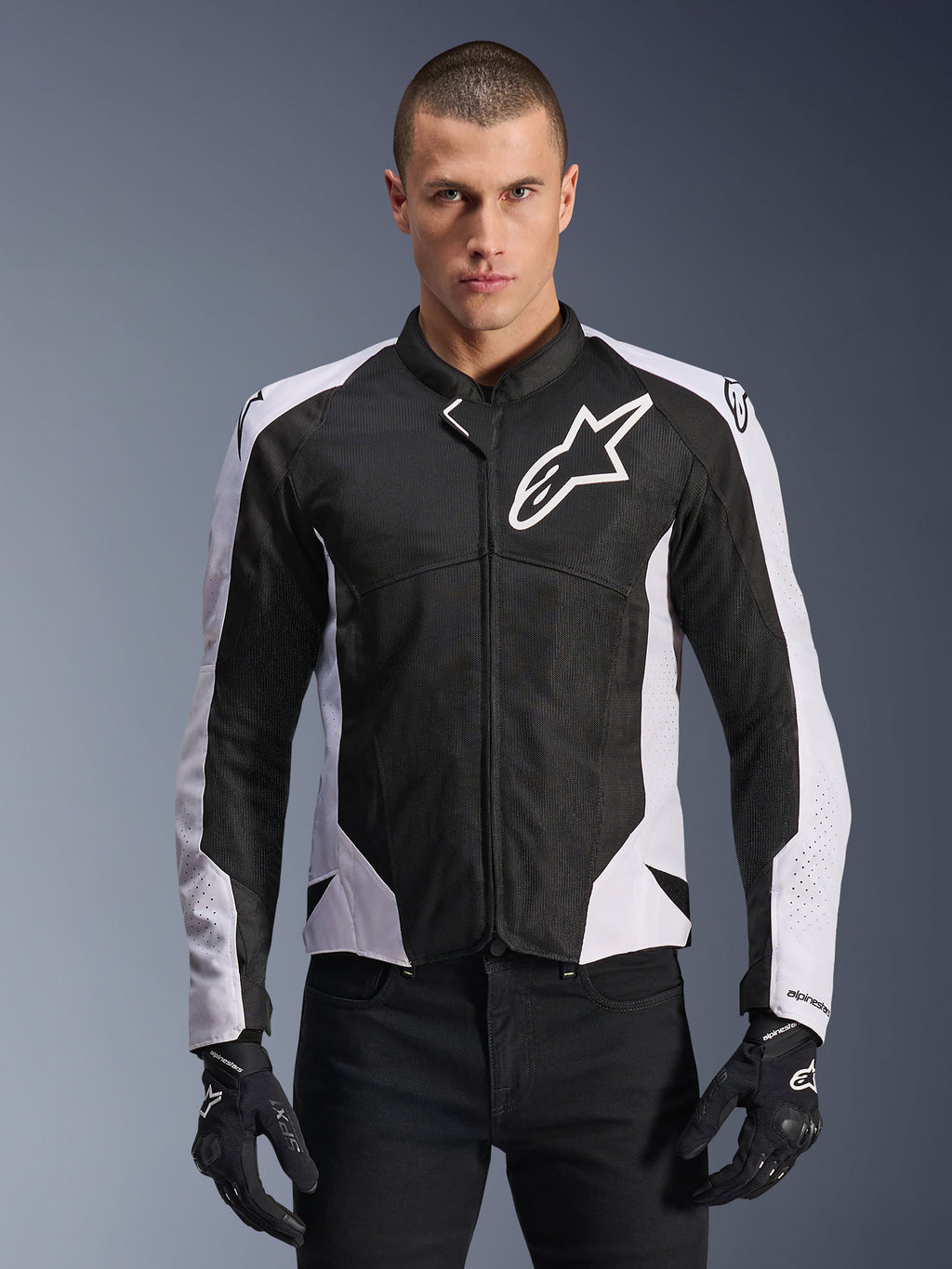 Alpinestars Viper Air V4 Jacke, Motorradjacke, Schwarz und Weiß, am Fahrer getragen, Tech-Mesh- und Textilkonstruktion mit weißen Schulterpanels, markantes Sternlogo auf der Brust, sportliches Performance-Design, kombiniert mit schwarzen Motorradhandschuhen