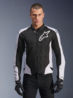 Alpinestars Viper Air V4 Jacke, Motorradjacke, Schwarz und Weiß, am Fahrer getragen, Tech-Mesh- und Textilkonstruktion mit weißen Schulterpanels, markantes Sternlogo auf der Brust, sportliches Performance-Design, kombiniert mit schwarzen Motorradhandschuhen