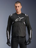Alpinestars T-SPS Air V2 Jacke, Textil-Motorradjacke, Schwarz mit weißen Akzenten, großes weißes Brustlogo, perforiertes Mesh-Design für Belüftung, getragen mit schwarzer Hose und Handschuhen