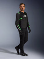 Male model wearing Alpinestars T-SPS Air V2 Jacket in Black and Fluo Green, paired with black riding pants and gloves, sport-cut textile jacket with mesh panels and neon accents, complete urban motorcycle outfit