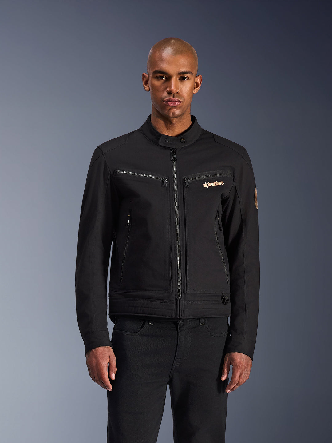 Alpinestars Bruiser Jacket, Black urban motorcycle jacket, front view on a model, featuring classic workwear aesthetics, zippered chest pockets, a buttoned collar, and Alpinestars logo, designed for urban riders