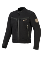 Alpinestars Bruiser Jacke, Schwarze Urban-Motorradjacke, Brust- und Seitentaschen mit Reißverschluss, goldfarbenes Branding und Oscar-Spiral-Schulteraufnäher, von Workwear inspiriertes Textildesign.
