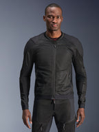 Alpinestars Troop-Air Jacke, schwarze Motorrad-Mesh-Jacke, getragen von einem Model mit passender schwarzer Mesh-Hose, atmungsaktive 2D-Tech-Mesh-Konstruktion mit verstärkten Schulterpanelen, Frontreißverschluss, moderne urbane Schutzausrüstung