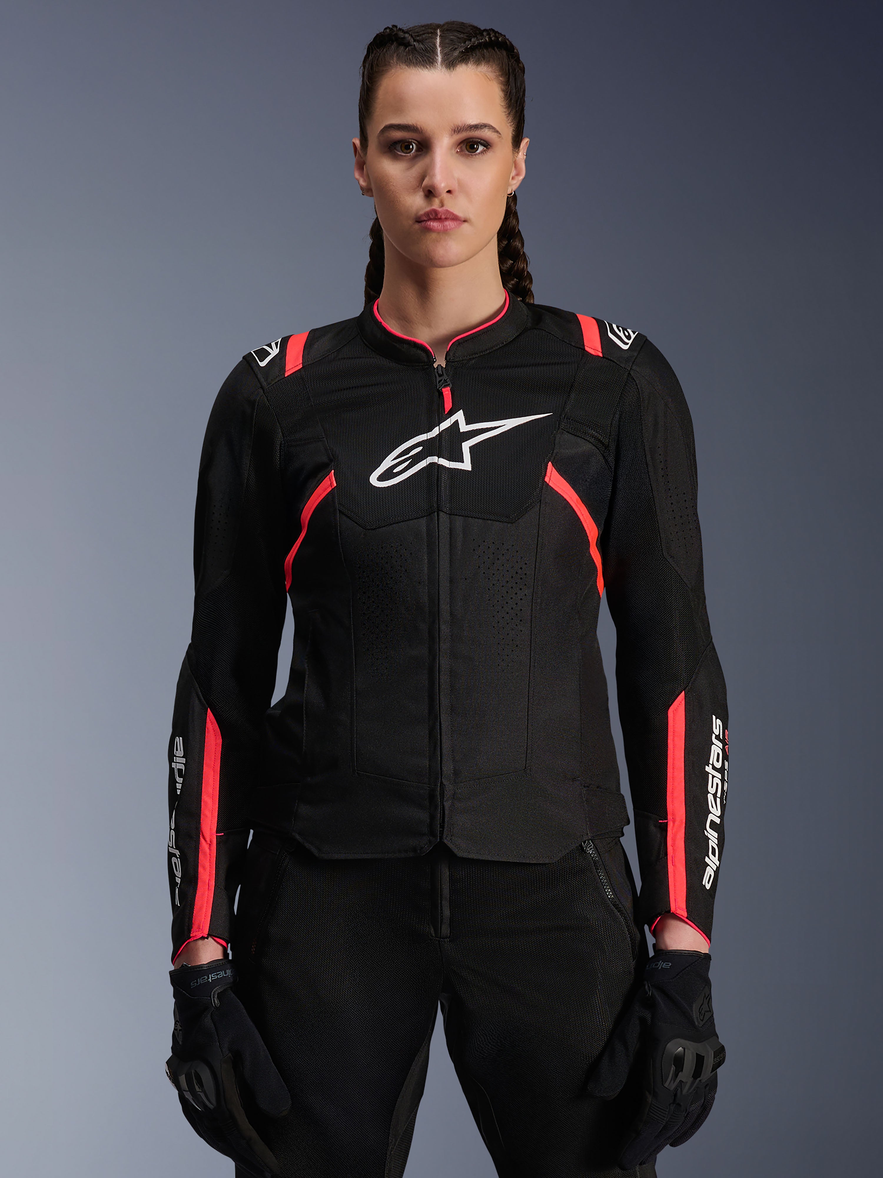 Alpinestars Stella T-SPS Air V2 Jacke, Damen-Motorradjacke, Schwarz und Diva Pink, belüftete Textilkonstruktion mit weißem Logo, pinkfarbene Racing-Akzente an Schultern und Ärmeln, getragen von einem weiblichen Model