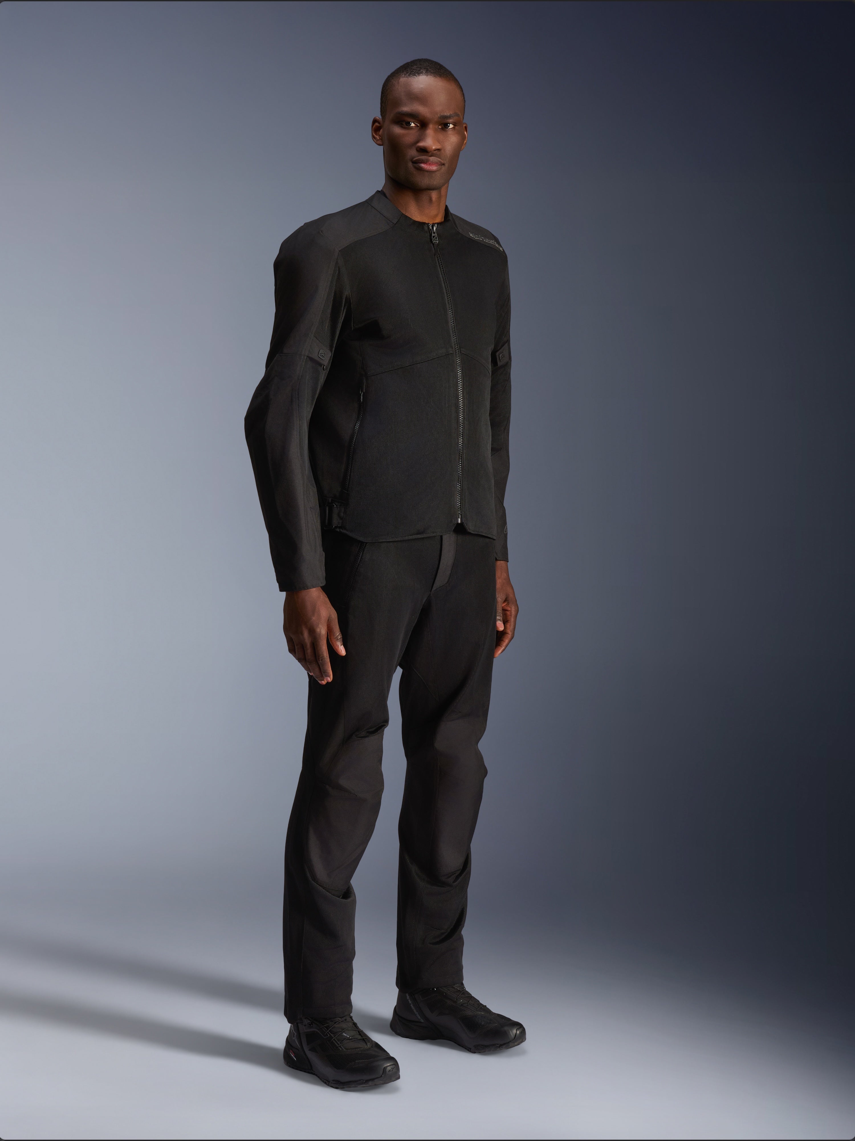 Alpinestars C-1 Air Jacket, Black, worn by a model with matching black motorcycle pants and shoes, featuring large tech mesh panels for airflow, clean urban aesthetic with a streamlined fit.