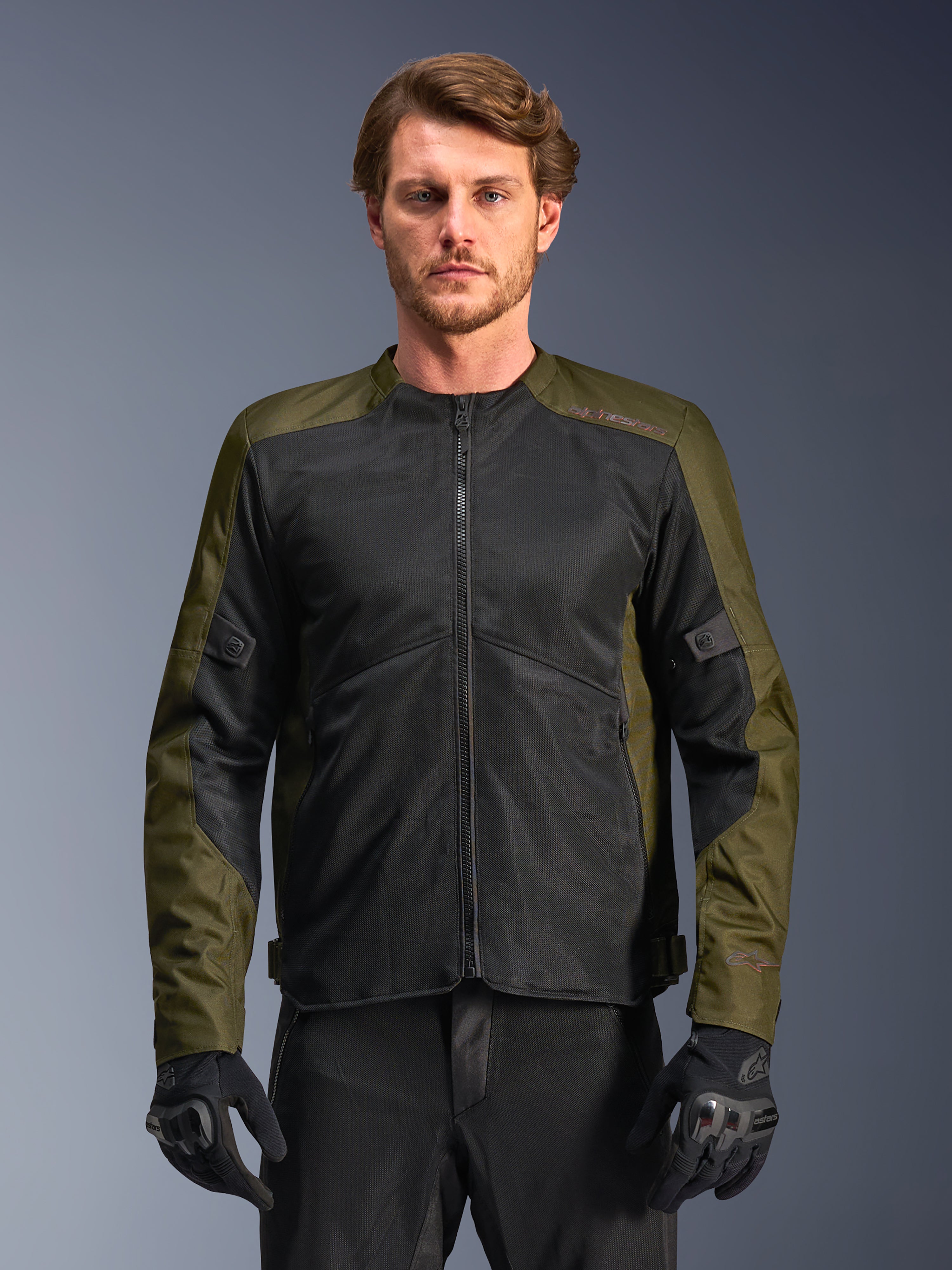 Alpinestars C-1 Air Jacke, Khaki und Schwarz, Motorradjacke für Herren mit großen Tech-Mesh-Einsätzen für maximale Belüftung, getragen von einem Model mit schwarzer Fahrhose und Handschuhen, urbanes zeitgemäßes Design für Pendler