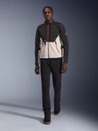 Männliches Model in der Alpinestars Provoke Jacke, urbane Motorradjacke in Schwarz und Metal Gray mit roten Reißverschluss-Akzenten, kombiniert mit schwarzer Hose und schwarzen High-Top-Schuhen, moderne Schutzausrüstung für Fahrten in der Stadt