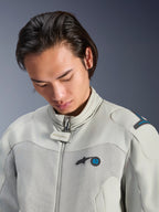 Männliches Model trägt die Alpinestars Circal-1 Air Jacke in Metal Gray mit Methyl Blue Akzenten, Nahaufnahme mit Fokus auf den Kragen, Mesh-Einsätze im Brustbereich und minimalistisches Logo-Branding, nachhaltige urbane Motorradausrüstung.