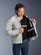 Alpinestars Circal-1 Air Jacke, Metal-Grau, offen gehalten, um das Mesh-Innenfutter und die Taschendetails zu zeigen, getragen von einem Model mit schwarzem Logo-T-Shirt und blauen Jeans, urbaner Motorrad-Stil