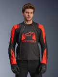 Alpinestars T-Stunt Air Jacke, Textil-Motorradjacke, Schwarz, Red Fluo und Dunkelrot, mit großem Stern-Logo und Mesh-Einsätzen für Luftzirkulation, getragen von einem Model mit schwarzen Handschuhen