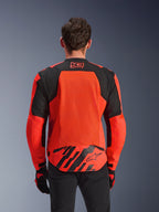 Alpinestars MM93 T-SPS Air V2 Jacke, Rückansicht, Rot Fluo und Schwarz, mit 93-Racing-Logo am Nacken, großem Mesh-Panel am Rücken für Luftzirkulation, unterer Rückenpartie mit Alpinestars Stern-Logo und geometrischen Streifen, getragen mit schwarzer Hose und Motorradhandschuhen
