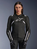 Alpinestars Stella T-Sps Air V2 Damenjacke, Textil-Motorradjacke, Schwarz-Weiß, mit perforierten Tech-Mesh-Einsätzen und weißem Alpinestars-Logo, getragen von einem Modell mit schwarzen Handschuhen, konzipiert für belüftete sommerliche Straßenfahrten
