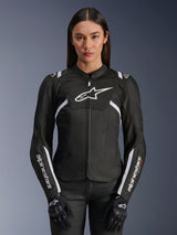 Alpinestars Stella T-Sps Air V2 Damenjacke, schwarz-weiße Textil-Motorradjacke mit perforierten Mesh-Einsätzen und weißen Logo-Akzenten, getragen mit schwarzen Handschuhen, konzipiert für sommerliche Straßenfahrten.