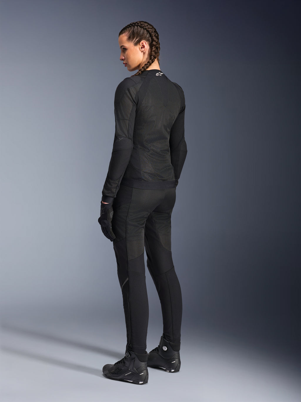 Alpinestars Stella Troop-Air Damenjacke, Schwarz, Rückansicht, getragen mit passender schwarzer Motorradhose, Handschuhen und Stiefeln, Slim-Fit-Konstruktion aus technischem Mesh für den urbanen Fahrstil