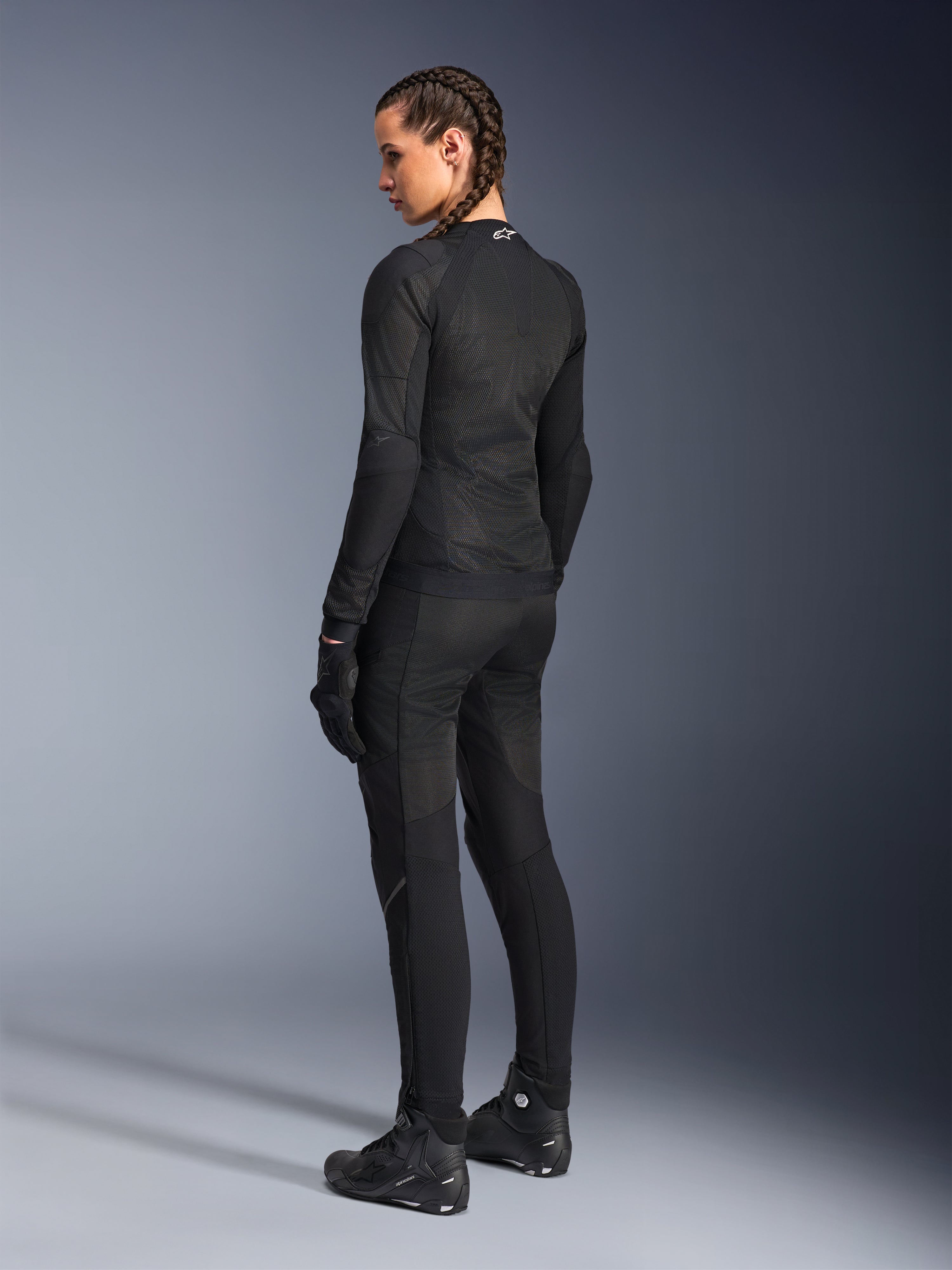 Alpinestars Stella Troop-Air Damenjacke, Schwarz, Rückansicht, getragen mit passender schwarzer Motorradhose, Handschuhen und Stiefeln, Slim-Fit-Konstruktion aus technischem Mesh für den urbanen Fahrstil