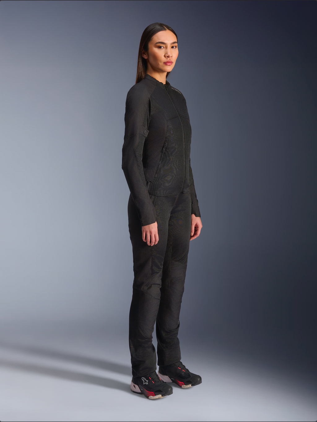 Alpinestars Stella C-1 Air Damenjacke in Schwarz, Textil-Motorradjacke mit Mesh-Einsätzen, kombiniert mit passender schwarzer Fahrhose und technischen Sneakern, Studioaufnahme eines kompletten urbanen Motorrad-Outfits.