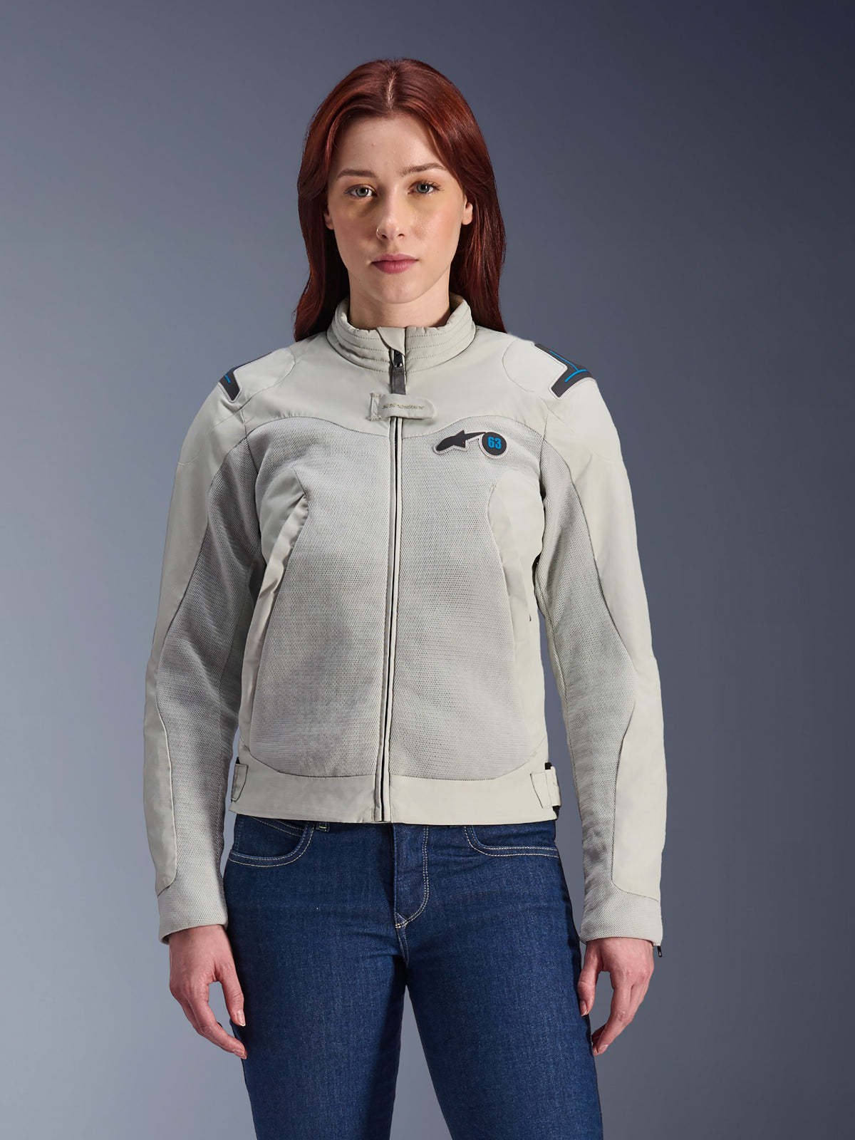 Alpinestars Stella Circal-1 Air Jacke, Damen-Motorradjacke, Metallgrau mit Methyl-Blau-Akzenten, Mesh-Einsätze für Luftstrom, Reißverschluss vorne mit Stehkragen, getragen von einem Modell über dunkelblauen Jeans