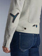 Alpinestars Stella Circal-1 Air Damenjacke in Metal Gray und Methyl Blue, Nahaufnahme der Rücken- und Ärmeldetails mit Mesh-Belüftungseinsätzen, neonblauen Akzenten an Ellbogen und Taille sowie verstellbarer Lasche, getragen mit dunkelblauen Denim-Jeans.
