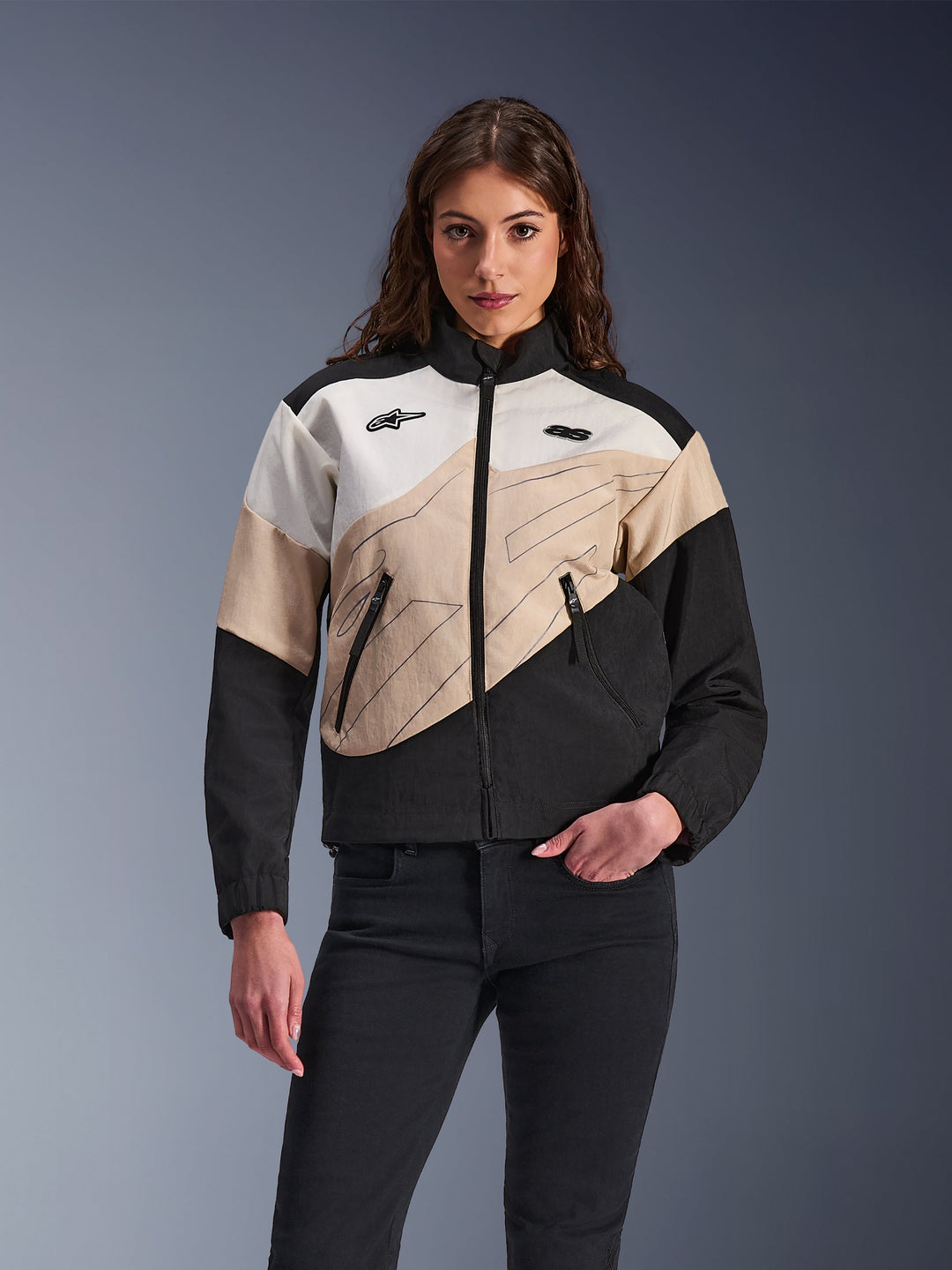 Alpinestars Stella Moshell Jacket, women's urban motorcycle jacket, asymmetrical color-blocked design in Black, Sand, and Off White, featuring front zipper and zippered hand pockets, modeled with black pants for a contemporary streetwear look.
