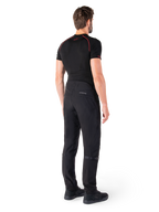 Alpinestars Alden Hose, Schwarz, urbane Motorradhose von hinten an einem Model gezeigt, getragen mit einem schwarzen kurzärmeligen Baselayer und schwarzen Motorradschuhen, mit gesteppten Details und reflektierendem MO.ST.EQ. Branding auf der Rückenpasse.