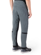 Alpinestars Alden Hose, Urban Grau, seitliche Rückansicht, Streetwear-inspirierte technische Motorradhose mit gesteppten Details an der Taille und schwarzen Wadenriemen, kombiniert mit grauen Motorradschuhen, moderne urbane Motorradausrüstung