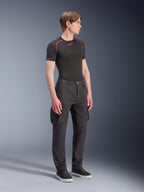 Male model wearing Alpinestars Flex-AST Cargo Pants - Short in Black, urban motorcycle cargo pants with side pockets and tapered legs, styled with a black base layer and sneakers, urban riding apparel.