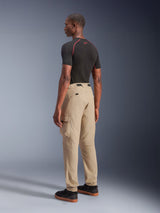 Alpinestars Flex-AST Cargo Pants, urban motorcycle pants, Light Beige, worn by a model from a rear side angle, featuring functional cargo pockets and elasticated cuffs, styled with a black short-sleeve shirt and black sneakers.