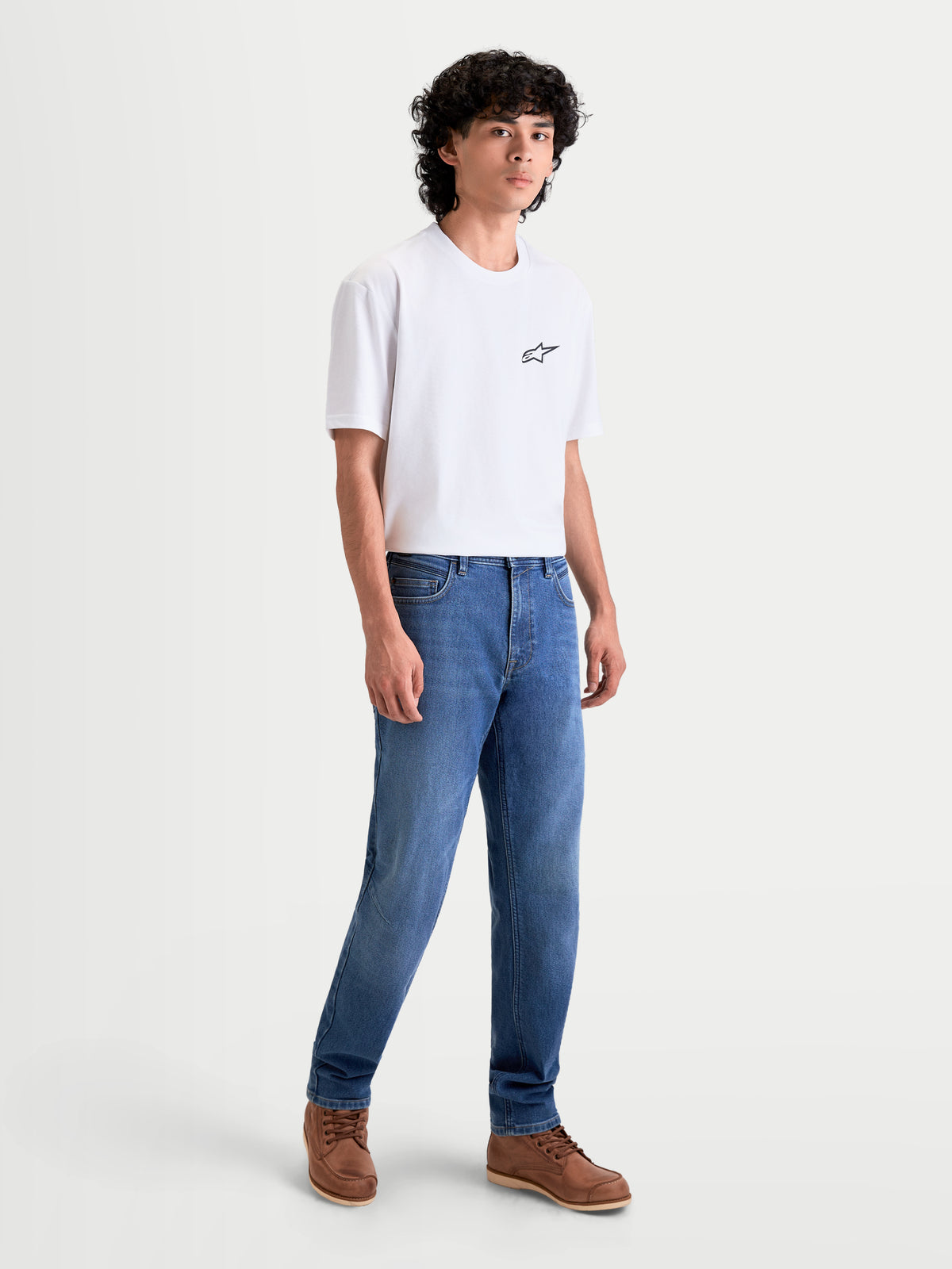 Alpinestars Flex Ast 7 Denim Hose, urbane Herren-Motorradjeans in Hellblau, Vorderansicht an einem Model mit weißem T-Shirt und braunen Schuhen, AA-zertifizierte technische Motorradhose