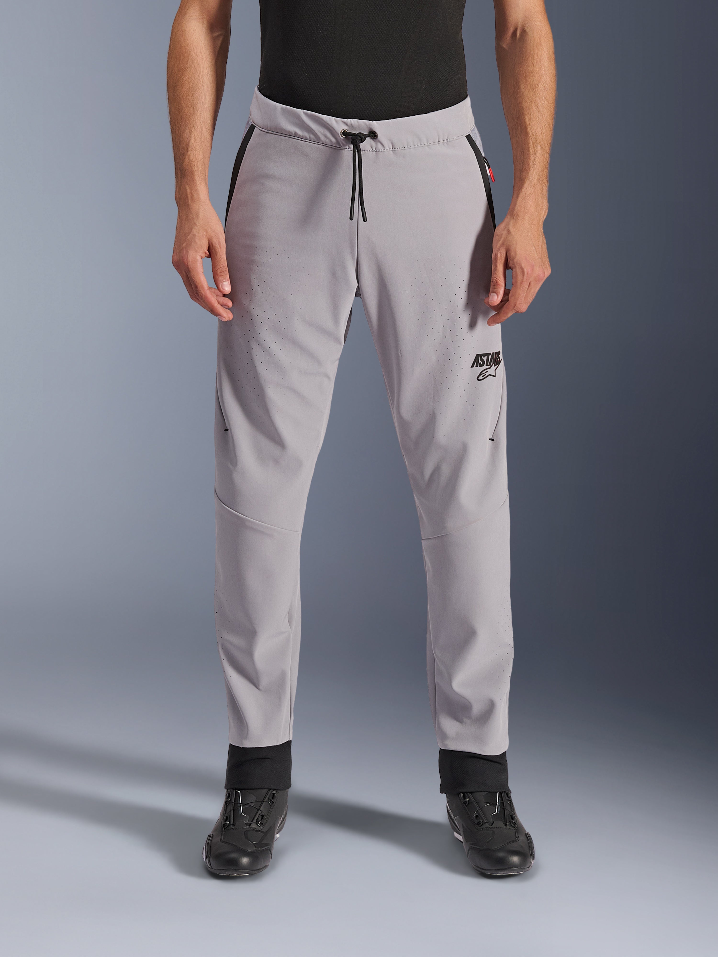Alpinestars Aeroshell Airflow Hose, Mid Gray, Vorderansicht mit laserperforierten Zonen an Oberschenkeln und Schienbeinen, schwarzer Kordelzug am Bund und schwarzes ASTARS-Logo, leichtes Softshell-Chassis für Fahrten bei warmem Wetter